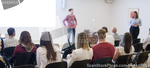 Image of Speaker giving presentation talk at business conference.