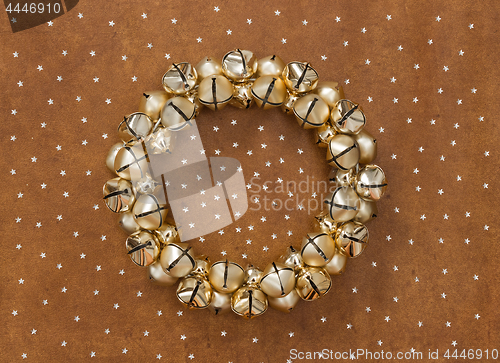 Image of Golden jingle bells wreath on leather background