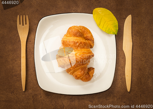 Image of Croissant on a plate decorated with autumn leaf