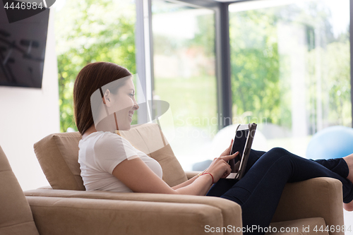 Image of woman sitting on sofa with tablet computer