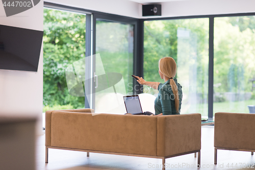Image of Young woman using laptop at home