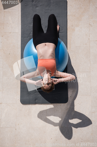 Image of woman doing exercise with pilates ball top view