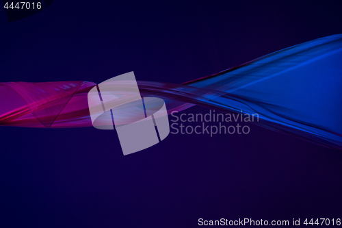 Image of Smooth elegant transparent blue cloth separated on blue background.