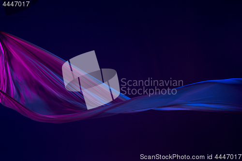 Image of Smooth elegant transparent blue cloth separated on blue background.