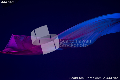 Image of Smooth elegant transparent blue cloth separated on blue background.