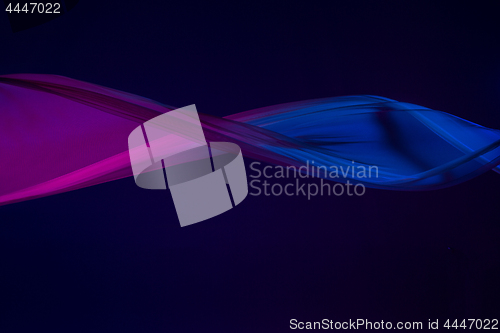 Image of Smooth elegant transparent blue cloth separated on blue background.