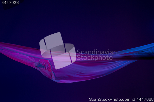 Image of Smooth elegant transparent blue cloth separated on blue background.