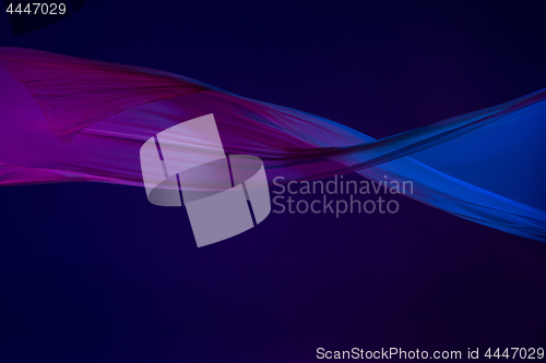 Image of Smooth elegant transparent blue cloth separated on blue background.