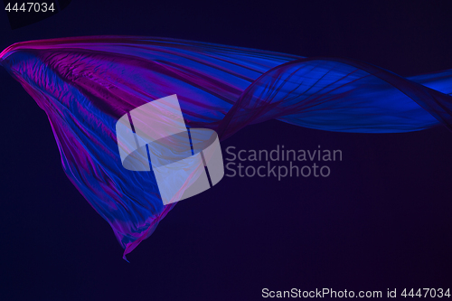 Image of Smooth elegant transparent blue cloth separated on blue background.