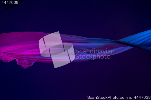 Image of Smooth elegant transparent blue cloth separated on blue background.