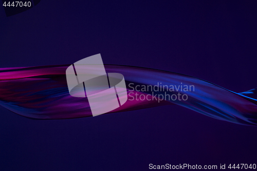 Image of Smooth elegant transparent blue cloth separated on blue background.