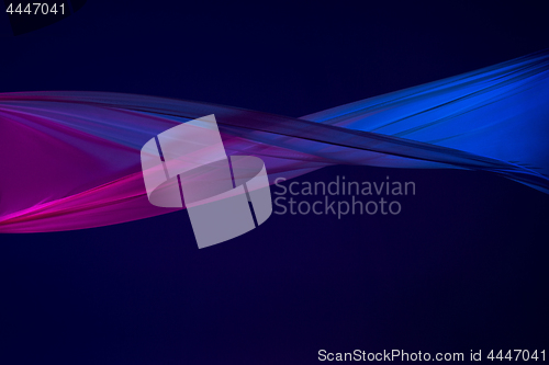 Image of Smooth elegant transparent blue cloth separated on blue background.