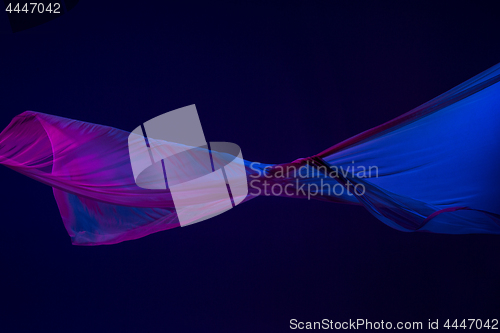 Image of Smooth elegant transparent blue cloth separated on blue background.