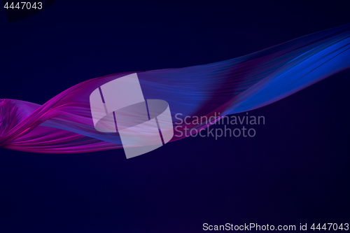 Image of Smooth elegant transparent blue cloth separated on blue background.