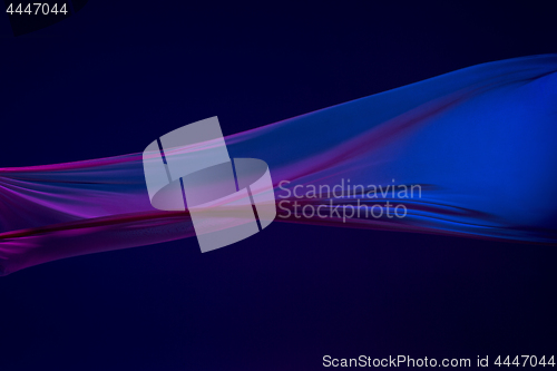 Image of Smooth elegant transparent blue cloth separated on blue background.