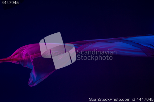 Image of Smooth elegant transparent blue cloth separated on blue background.