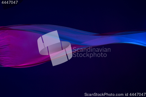 Image of Smooth elegant transparent blue cloth separated on blue background.