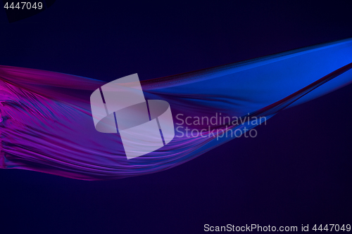 Image of Smooth elegant transparent blue cloth separated on blue background.