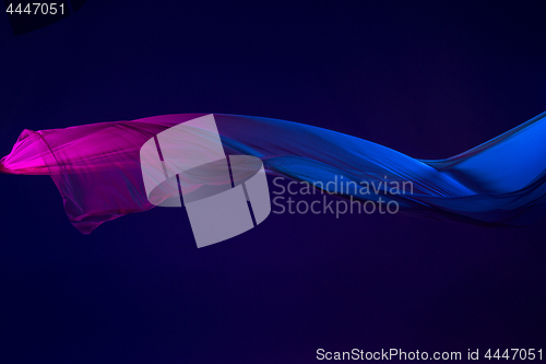 Image of Smooth elegant transparent blue cloth separated on blue background.