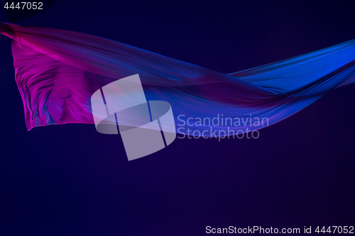 Image of Smooth elegant transparent blue cloth separated on blue background.