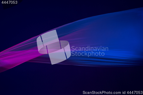 Image of Smooth elegant transparent blue cloth separated on blue background.