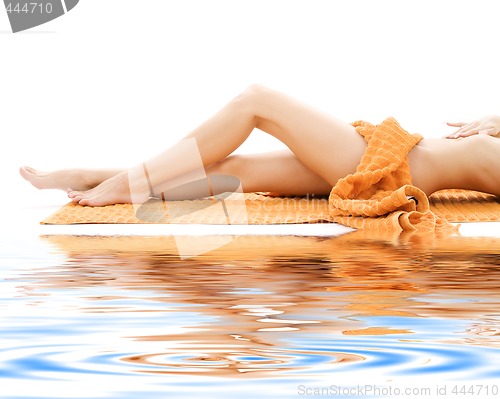 Image of long legs of relaxed lady with orange towel