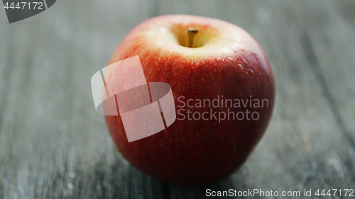 Image of Ripe red apple on wooden desk