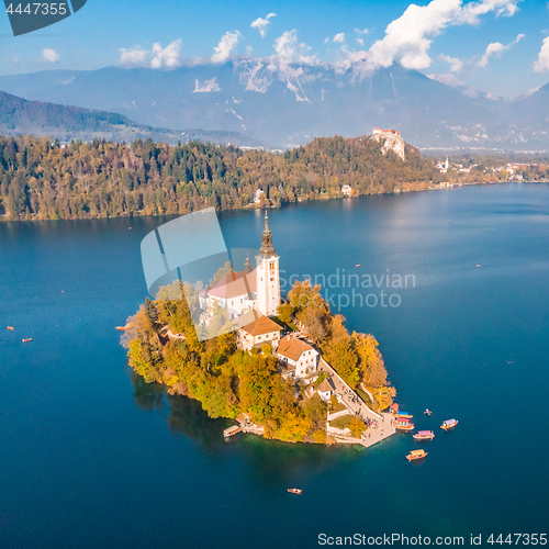 Image of Aerial view of Bled island on lake Bled, and Bled castle and mountains in background, Slovenia.