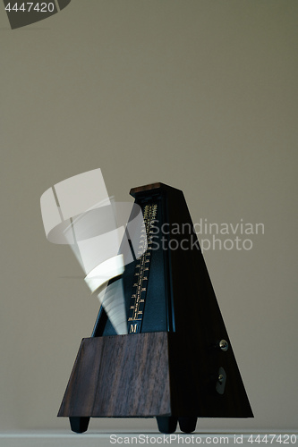 Image of Vintage metronome, on a black background.