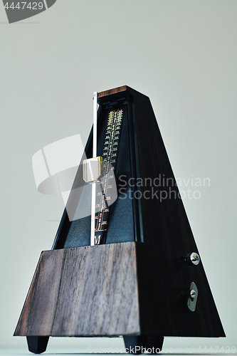 Image of Vintage metronome, on a black background.