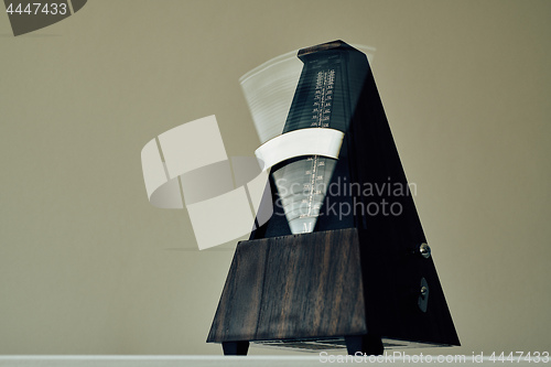 Image of Vintage metronome, on a black background.