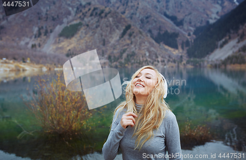 Image of Woman wearing wireless headphones at the lake