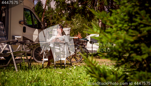 Image of Woman with a mug of coffee near the camper. Caravan car Vacation