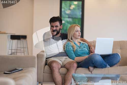 Image of young happy couple relaxes in the living room