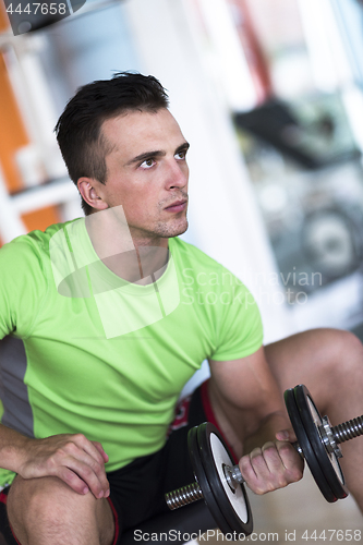 Image of handsome man working out with dumbbells