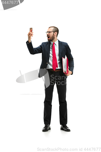 Image of Angry businessman talking on the phone isolated over white background in studio shooting