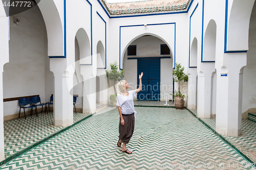 Image of Woman admiring traditional moroccan architecture in one of the palaces in medina of Marrakesh, Morocco.