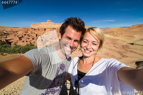 Image of Active happy couple taking selfie on travel at Ait Benhaddou kasbah, Ouarzazate, Morocco.