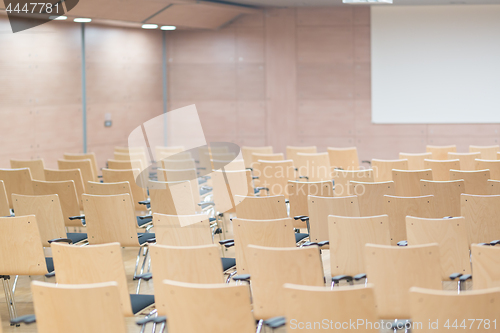 Image of Empty wooden seats in a cotmporary lecture hall.