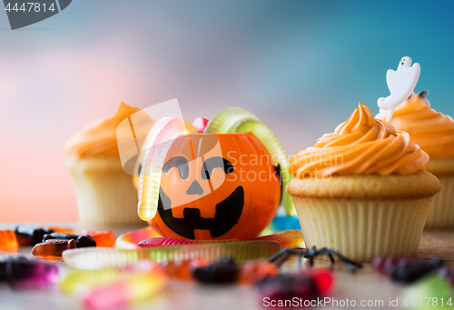 Image of halloween party decorated cupcakes on wooden table