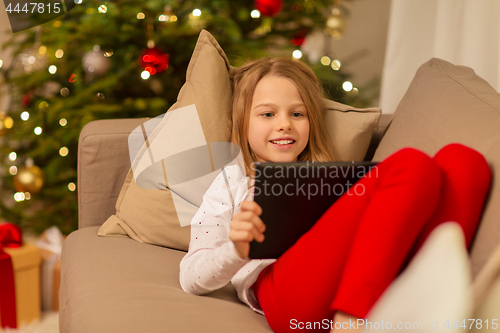 Image of smiling girl with tablet pc at christmas home