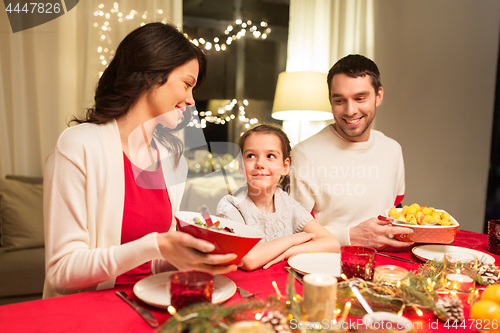 Image of happy family having christmas dinner at home