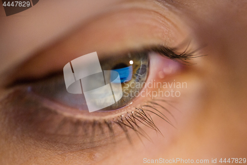 Image of close up of woman eye looking at computer screen