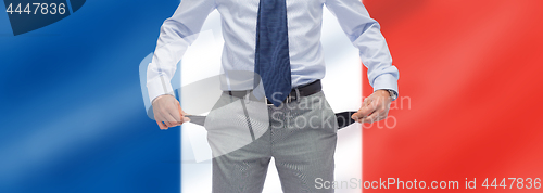 Image of businessman with empty pockets over flag of france