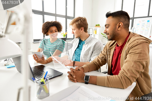 Image of creative team discussing papers at office