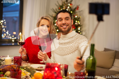 Image of couple taking picture by selfie stick at christmas