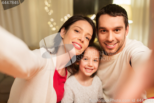 Image of happy family taking selfie at christmas