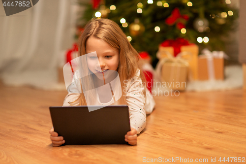 Image of smiling girl with tablet pc at christmas home