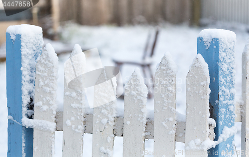 Image of Snow covered picket fence in light falling snow