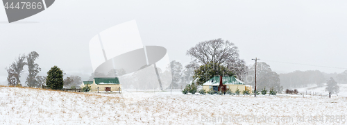 Image of Farm house and outbuildings in the snowy landscape